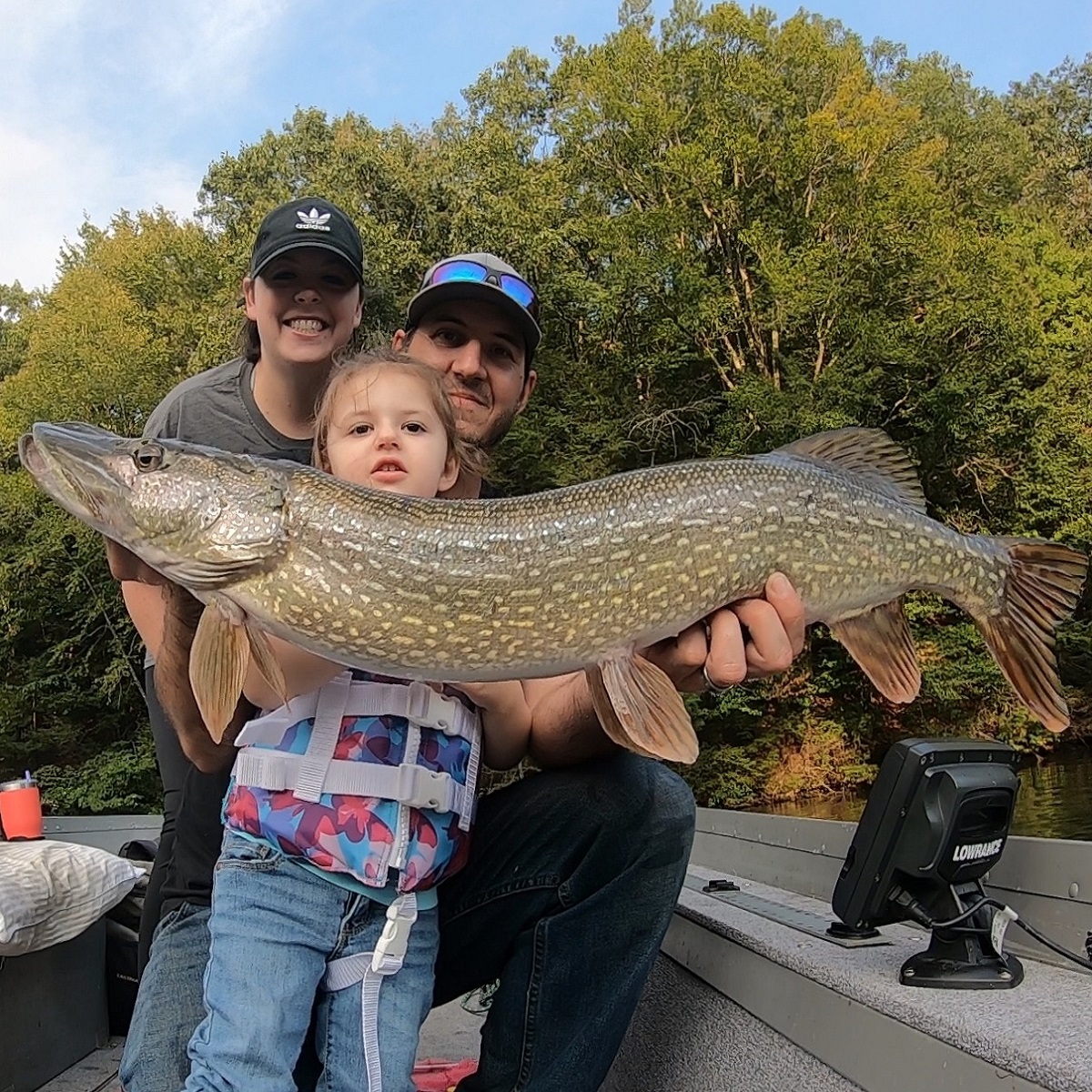Family with a big northern pike.