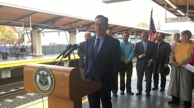 Governor Malloy speaking at podium at Wallingford train station