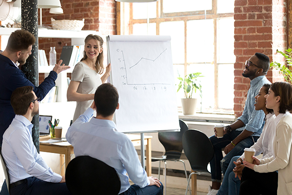 Group at meeting talking about growth of sales graph