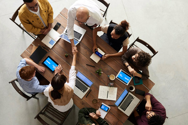 Business people shaking hands across a table.