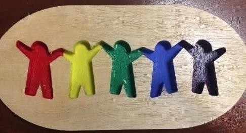 Wood with cut-outs of people shapes.  Each person is a different color of the rainbow.