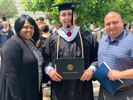 Vince in full commencement regalia with his diploma