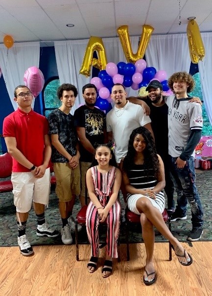 Vince with many other people at a celebration with balloons in the background