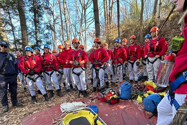 Fire academy trainees learning techniques in the woods.