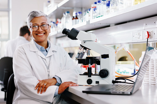  Scientist with microscope and computer
